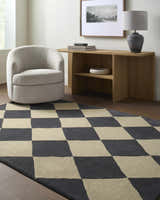 Living room scene with Aradia Charcoal Area Rug, beige chair, and wood console table with lamp. Roomscene-Rectangle