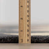 Close-up of the Aradia Charcoal Area Rug showing its pile height with a ruler. Pile