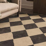 Close-up of the hand-tufted Aradia Charcoal Area Rug, a wool rug with a contemporary checkerboard pattern. Roomscene-Rectangle