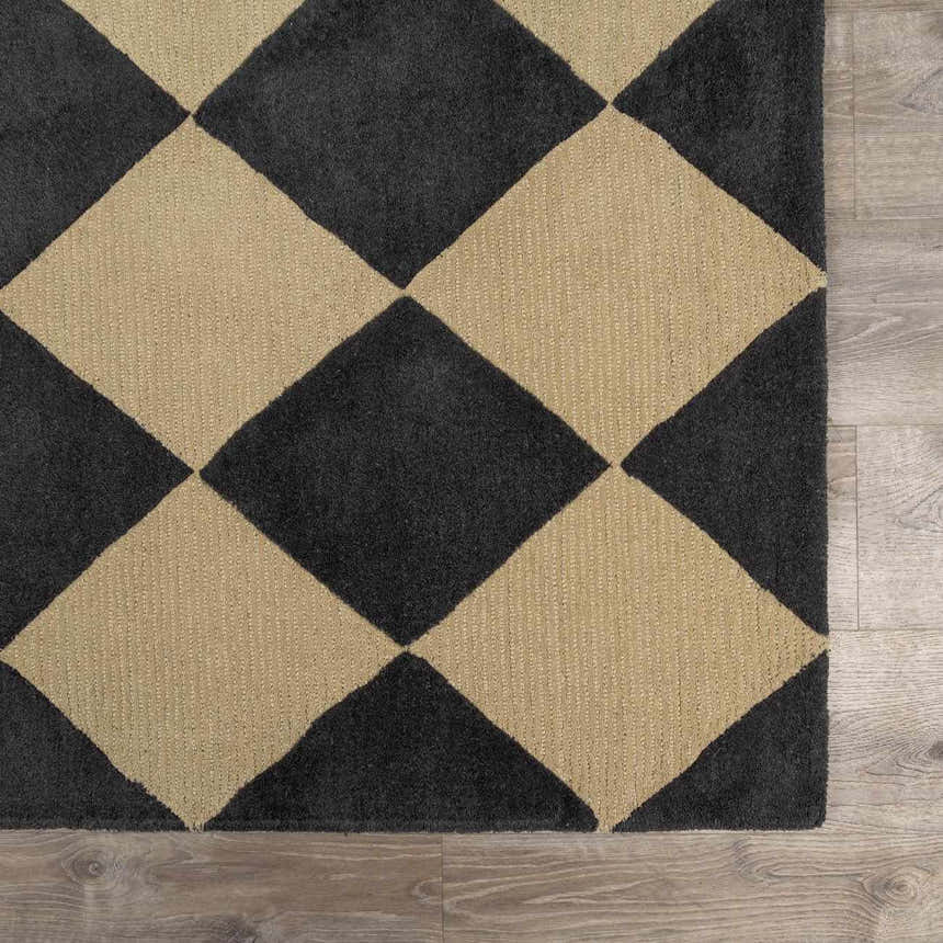 Close-up of the Aradia Charcoal Area Rug showing a large diamond pattern in charcoal and beige. Wool texture visible. Swatch