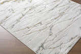 Close-up of the Zelah Area Rug showing its beige, charcoal, and gold contemporary pattern and soft texture. Corner