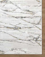 Close-up of the Zelah Area Rug, featuring a contemporary beige, charcoal, and gold marble-like pattern. Corner
