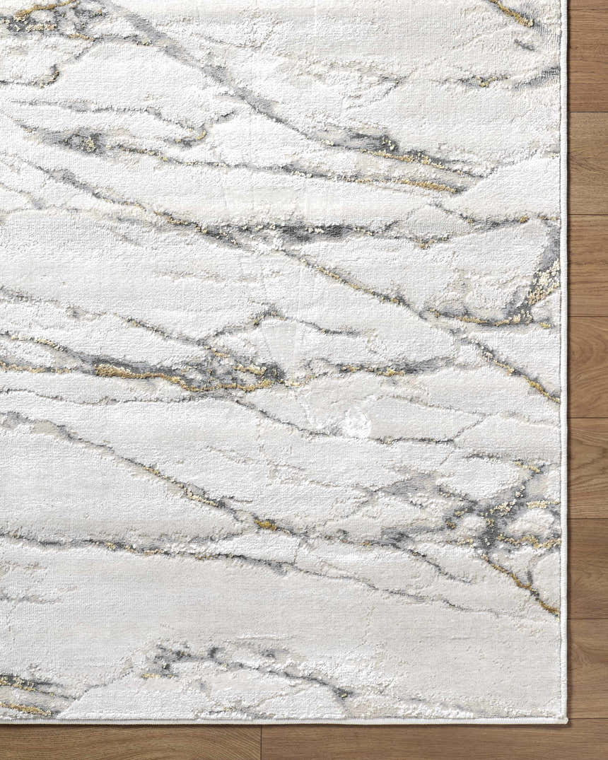Close-up of the Zelah Area Rug, featuring a contemporary beige, charcoal, and gold marble-like pattern. Corner