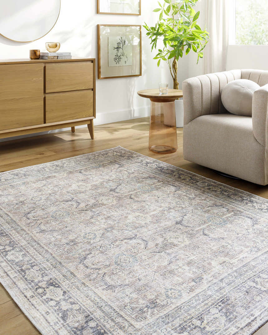 Living room scene with light wood floors, Zahar Washable Area Rug in light silver, gray, and cream, and a beige chair. Roomscene-Rectangle