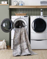 Laundry room scene with Zahar Washable Area Rug partially in washing machine. Farmhouse style with silver gray tones. Washing-Machine