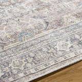 Close-up of the Zahar Washable Area Rug showcasing its traditional light silver, gray, and warm gray pattern and woven texture. Texture