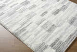 Close up of the ivory and peach Alaura Area Rug with a contemporary shag design. Corner