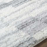 Close-up of the ivory and gray Alaura Area Rug, a soft shag rug with horizontal stripes. Texture