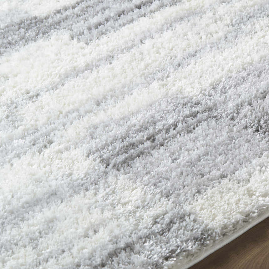 Close-up of the ivory and gray Alaura Area Rug, a soft shag rug with horizontal stripes. Texture