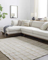 Living room with a cream sectional sofa and the Zared Checkered Jute Area Rug in ash, light silver, and sage. Roomscene-Rectangle