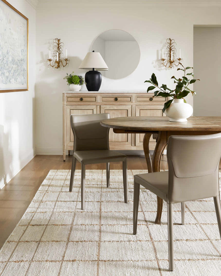 Dining room scene with a round table and Zared Checkered Jute Area Rug in ash, light silver, sage, and silver gray. Roomscene-Rectangle
