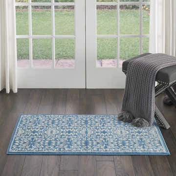 Entryway with Nourison Jubilant Ivory Blue Farmhouse Indoor Area Rug, dark wood floor, bench, and white french doors.