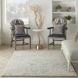 Living room scene with the Nourison Interlock Blue Multicolor rug, chairs, table, and a city view.