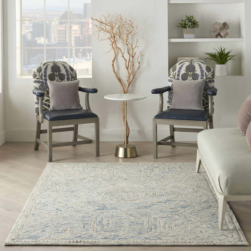 Living room scene with the Nourison Interlock Blue Multicolor rug, chairs, table, and a city view.