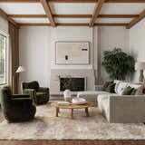 Living room with a Nourison Dreamy Shag Ivory Beige rug, green chairs, sectional sofa, and wooden accents.