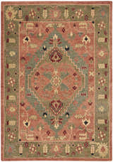 Close-up of the Nourison Tahoe Rust rug. Traditional design with rust, green, and cream floral and geometric patterns. 100% wool texture.