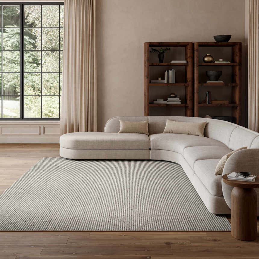 Living room scene with a curved sofa and Nourison Natural Texture Ivory Grey Farmhouse Indoor Area Rug.