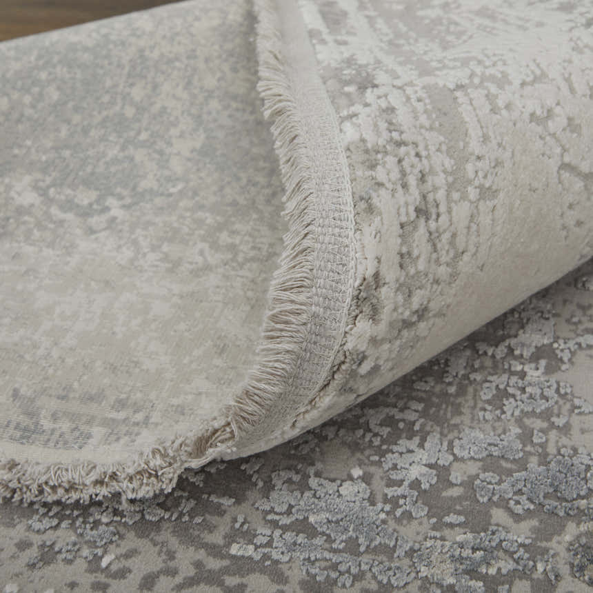 Close-up of Feizy Cadiz Taupe/Gray/Silver Area Rug showing abstract pattern, fringe detail, and soft texture. Fold