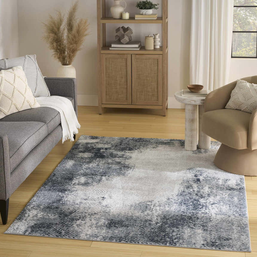 Living room scene with grey sofa and Nourison Dekor Grey Navy rug.