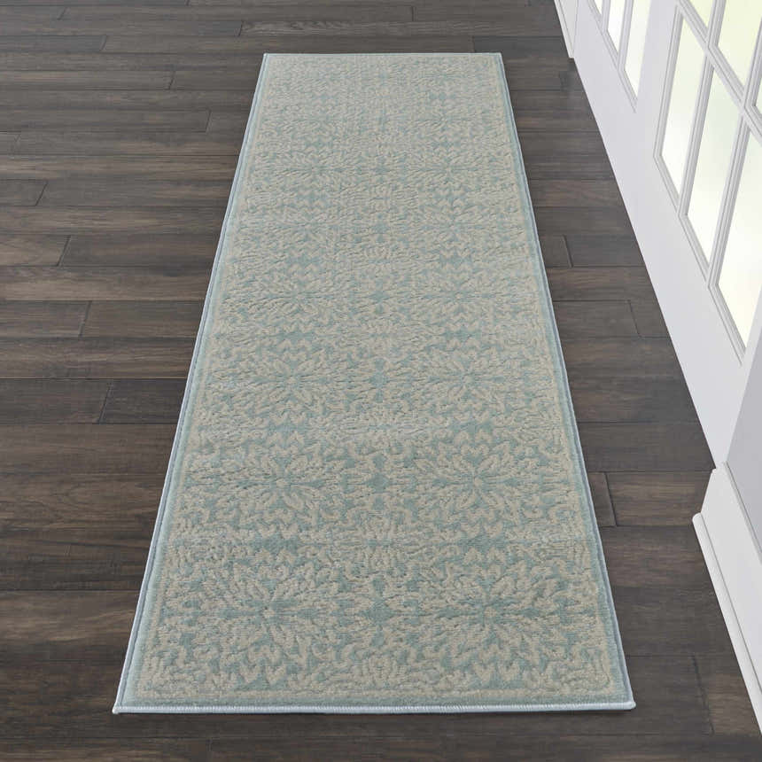 Close-up of Nourison Jubilant Ivory Green runner rug. Farmhouse style rug with floral pattern on dark wood floor.