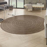 Living room scene with a round Nourison Tulum Brown Outdoor Area Rug on light wood floors.