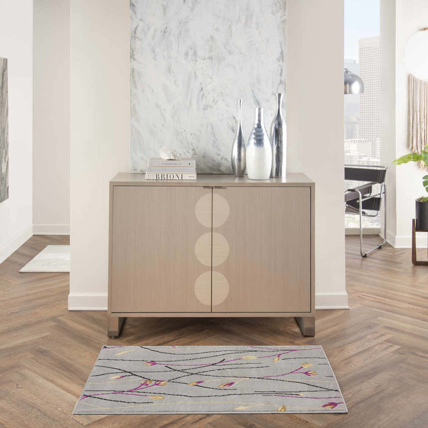 Living room scene with Nourison Grafix Grey Contemporary Indoor Area Rug, wood floors, and modern cabinet.