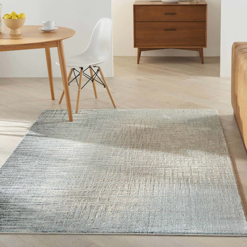 Modern dining room with Nourison Marmara Teal/Grey rug, wood table, white chair, and mid-century credenza.