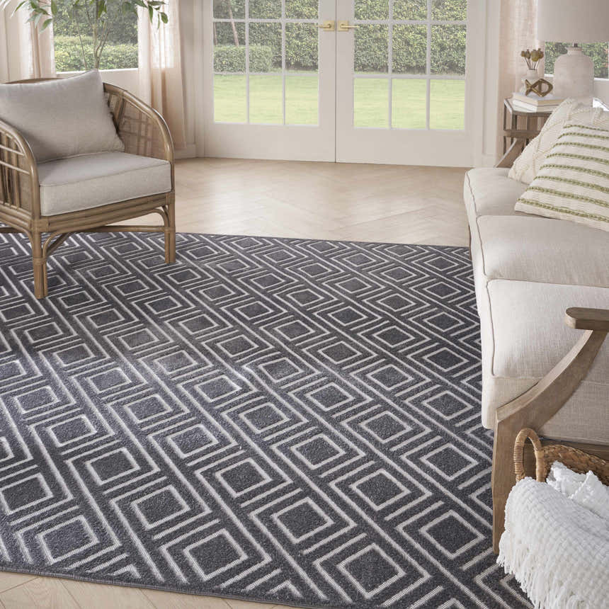 Living room scene with a Nourison Care Free Grey Modern Indoor Area Rug.