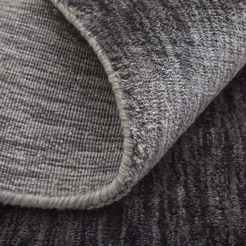 Close-up of the hand-woven Feizy Marlowe rug. Gray and taupe viscose with a subtle chevron pattern and textured pile. Fold