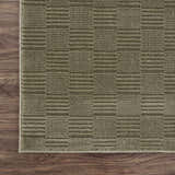 Close-up of the Kazuma Green Washable Area Rug showing its textured, contemporary stripe pattern and soft gray-green color. Corner
