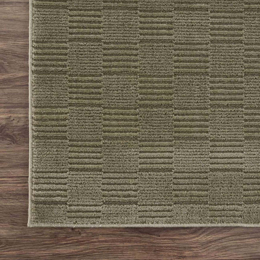 Close-up of the Kazuma Green Washable Area Rug showing its textured, contemporary stripe pattern and soft gray-green color. Corner