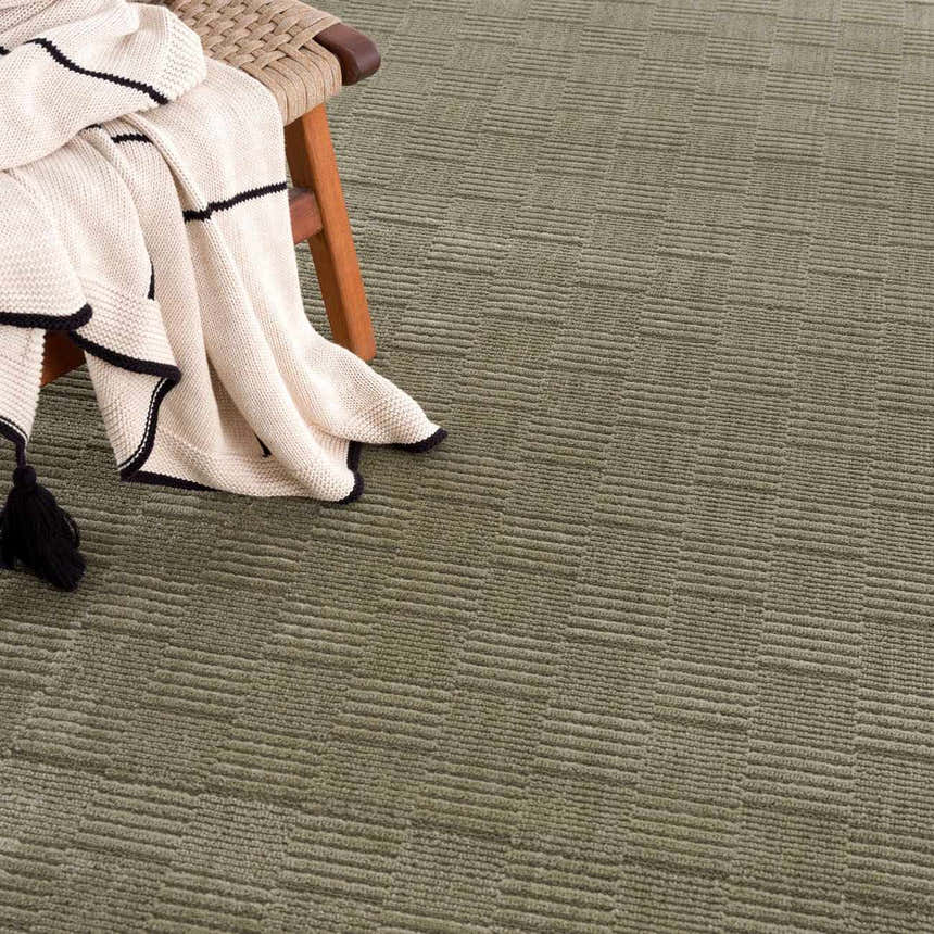Close-up of the Kazuma Green Washable Area Rug, showcasing its textured, linear pattern and soft gray-green color. Styleshot