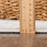 Close-up of the Gaiwan Cream Gray Washable Area Rug showing pile height with a ruler on a wood floor. Pile