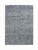 Close-up of the Calvin Klein Tulsa Denim Plush Rug. Features a textured, heathered denim blue and white design.