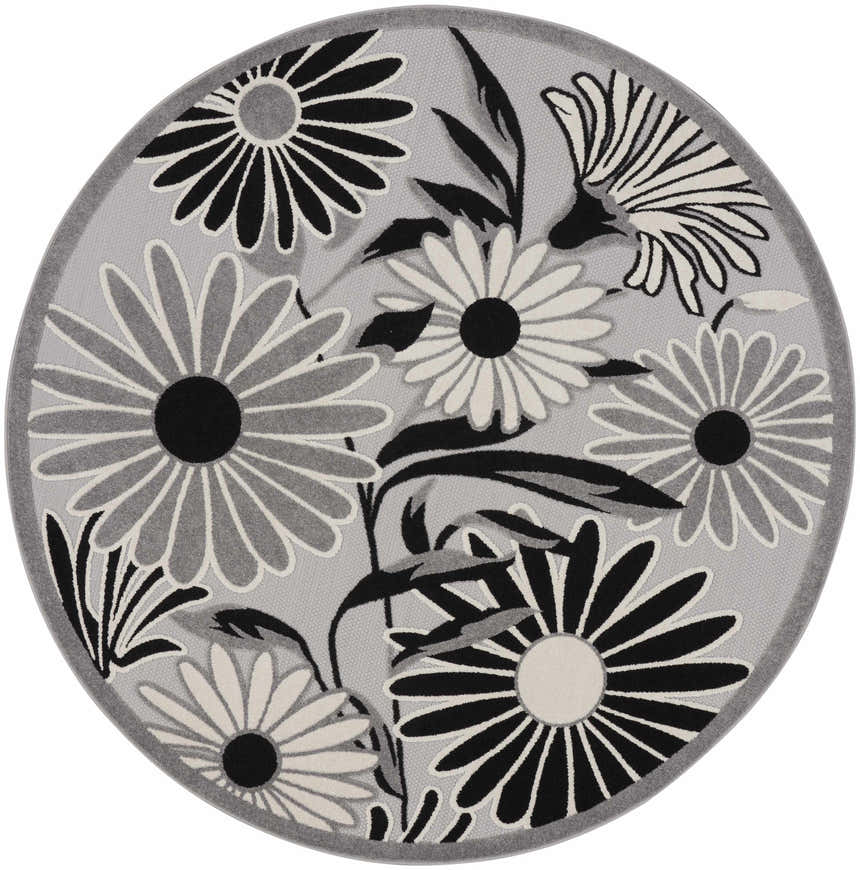 Close-up of a round Nourison Aloha Black White Outdoor Area Rug with a black and white floral pattern on a gray background.