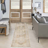 Entryway with a Nourison Astra Beige Vintage Runner Rug, gray bench, leather sofa, and wooden doors.
