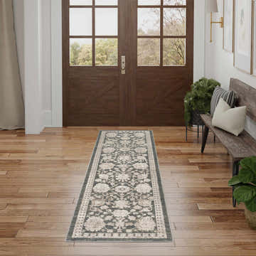 Entryway with a Nourison Eco Cycle Charcoal Vintage rug, wood floors, and a bench.