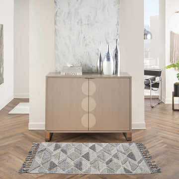 Modern living room scene with a Nourison Paxton Grey Charcoal rug, wood floors, and a taupe cabinet.
