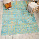 Styled room featuring Nourison Madera Sky Blue Tribal rug. Sky blue and gold geometric pattern on a wood floor.