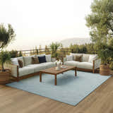 Outdoor patio scene with sofas and a Nourison Positano Aqua rug, offering a serene and stylish space.