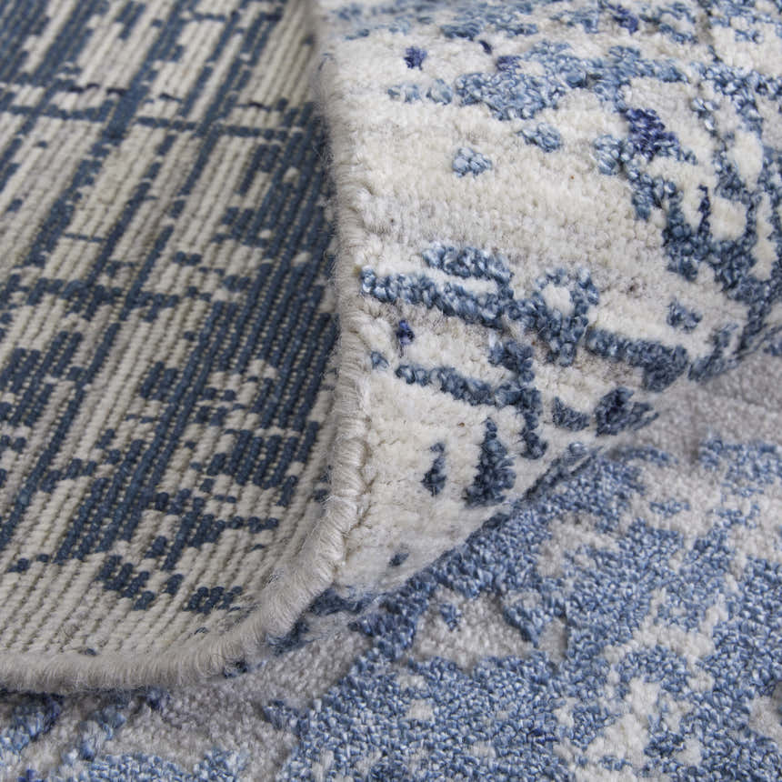 Close-up of the Feizy Eastfield rug. Blue and ivory rug with abstract geometric pattern and hand woven texture. Fold