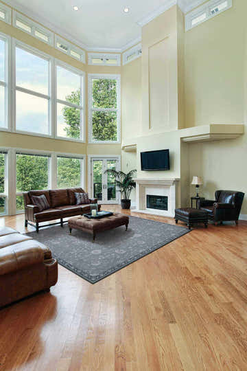 Bright living room with leather furniture and Nourison Regal Slate Persian rug in taupe.