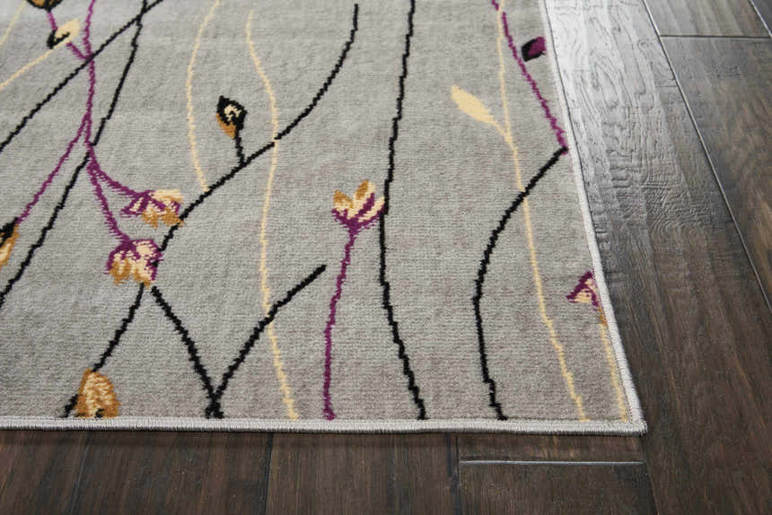 Close-up of the Nourison Grafix Grey Contemporary Indoor Area Rug with a floral design in purple, yellow, and black.