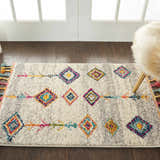 Living room scene with Nourison Nomad Cream Grey Tribal rug, colorful diamond pattern, wood floors, and a furry chair.