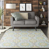 Living room scene with a Waverly Sun N' Shade Jade rug, gray loveseat, wood wall, and coastal decor.