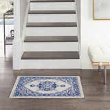 Entryway with Nourison Whimsicle Ivory Blue Farmhouse Indoor Area Rug, wood floors, white stairs, and modern bench.