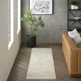 Modern living room with a DKNY Grand Street Ivory Beige runner rug, leather couch, and dark wood floors.