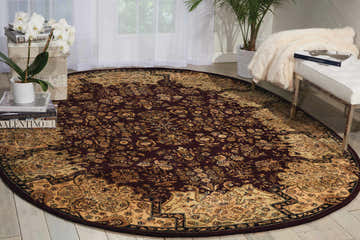 Living room scene with oval Nourison 2000 Plum Persian rug, dark purple floral pattern, white bench, and natural light.