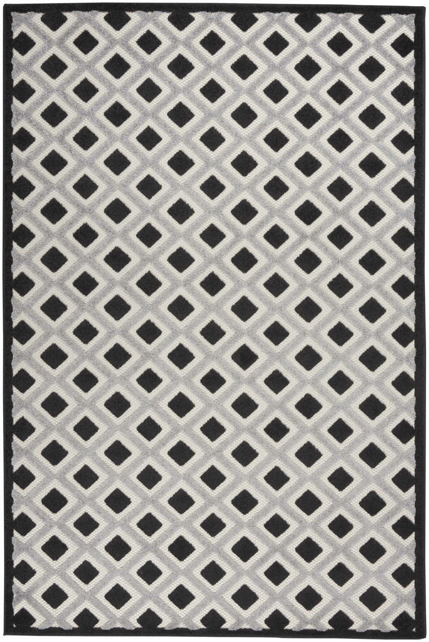 Close-up of the Nourison Aloha Black White Modern Area Rug featuring a geometric diamond pattern in black, white, and gray.