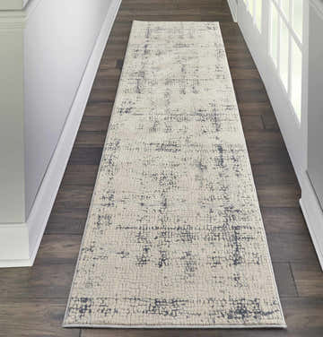 Hallway with Nourison Rustic Textures Ivory/Blue runner rug on dark wood floor, white walls and door.
